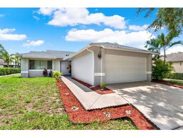 Charming single-story home featuring a well-manicured lawn and a two-car garage with ample parking at 963 Beach Breeze Dr, Orlando, FL 32835