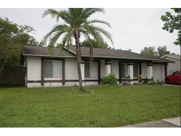 Inviting single-story home featuring a well-maintained lawn and mature palm tree in the front yard at 11418 Ashboro Dr, Orlando, FL 32837