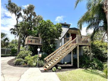 Unique home design with elevated wooden deck, lush landscaping, and mature trees at 1292 Nadine Dr, Deltona, FL 32738
