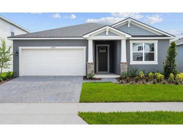 Charming one-story home featuring a two-car garage, covered entryway, and neatly landscaped front yard at 13232 Pergola Ave, Orlando, FL 32832