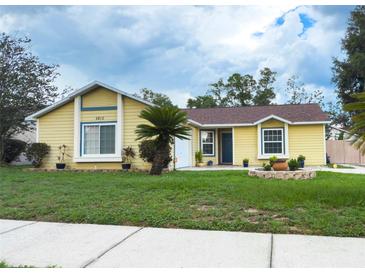 Charming single-Gathering home with a well-maintained lawn and landscaping, complemented by a classic yellow exterior at 5815 England Ave, Orlando, FL 32808
