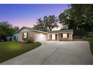 Charming single-story home featuring a well-manicured front yard and attached garage, perfect for suburban living at 5820 Indian Hill Rd, Orlando, FL 32808
