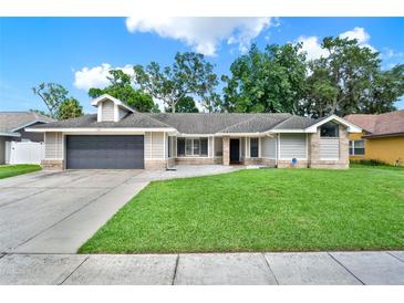 Charming single-story home with a well-manicured lawn and a two-car garage at 679 N Endeavour Dr, Winter Springs, FL 32708