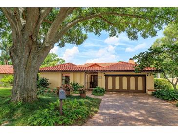 Charming single-story home with a brick driveway, clay tile roof, and mature landscaping at 8143 Terragona Ct, Orlando, FL 32836