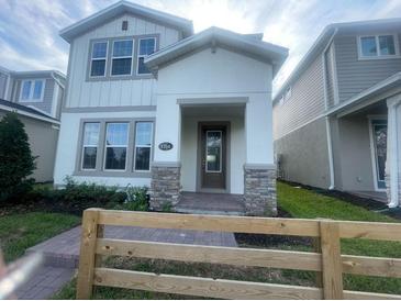 Charming two-story home featuring a welcoming front porch with stone accents and a well-manicured lawn at 1354 Twelve Oaks Rd, St Cloud, FL 34771