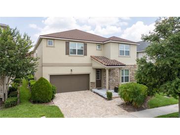 Charming two-story home featuring a brown roof, stone accents, a two-car garage, and a well-manicured front yard at 1505 Nassau Point Trl, Kissimmee, FL 34747