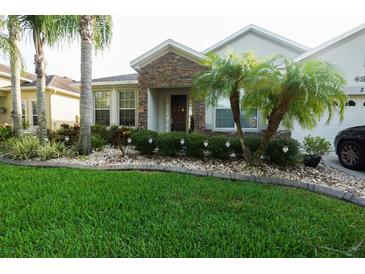 Charming single-story home with stone accents, lush landscaping, and a well-manicured lawn at 2237 Osprey Woods Cir, Orlando, FL 32820