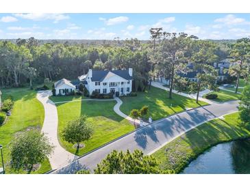 Stunning white mansion with manicured lawn, lush trees, and winding driveway creates an inviting estate at 2487 River Tree Cir, Sanford, FL 32771