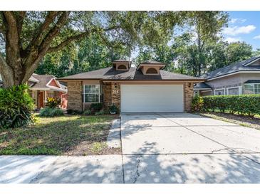 Charming brick home featuring a two-car garage, manicured lawn, and a welcoming front entrance at 316 Dornoch Ct, Winter Springs, FL 32708