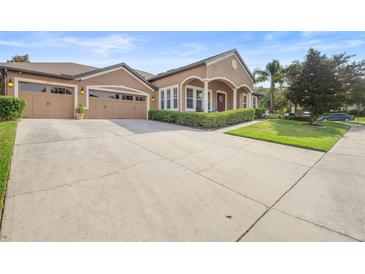 Charming home boasts a well-manicured lawn and a spacious driveway leading to a three-car garage at 3551 Statham Dr, Apopka, FL 32712