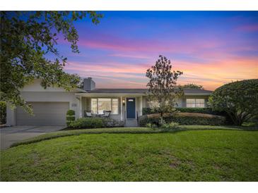 Charming single-story home with a well-manicured lawn and inviting curb appeal under a gorgeous sunset sky at 676 Dunblane Dr, Winter Park, FL 32792