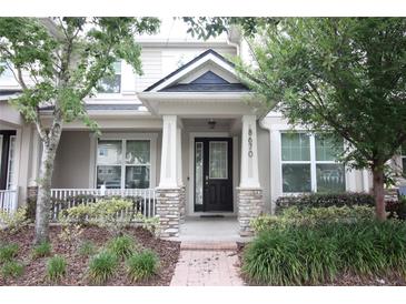 Charming front porch with stone accents and manicured landscaping, offering a welcoming entrance at 8670 Vedder Ln, Orlando, FL 32832