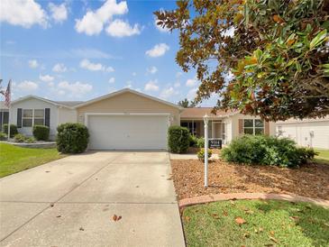 Charming single-story home featuring a well-maintained front yard and a two-car garage at 9514 Se 168Th Maplesong Ln, The Villages, FL 32162