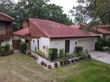 Charming single-story home featuring a red tile roof and a well-manicured front yard with lush landscaping at 1053 W Pebble Beach Cir, Winter Springs, FL 32708