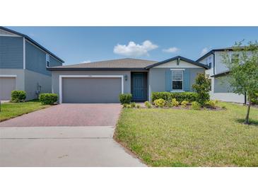 Charming single-story home featuring a well-manicured lawn, brick driveway, and a cozy, inviting entrance at 17363 Million Lakes Ct, Clermont, FL 34714