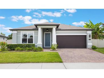 Charming one-story home showcasing a well-manicured lawn and a brick driveway leading to a two-car garage at 1740 Standing Rock Cir, Oakland, FL 34787