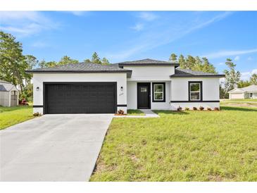 Charming single-story home featuring a modern design, black trim, and an attached two-car garage at 3749 Sw 131St St, Ocala, FL 34473