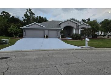 Charming home featuring a three-car garage, well-manicured lawn, and tasteful landscaping at 4351 Winding Oaks Cir, Mulberry, FL 33860