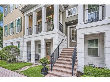 Inviting townhome exterior with brick steps, black railings, and covered porch, perfect for enjoying the outdoors at 524 Lanark Ct, Orlando, FL 32806