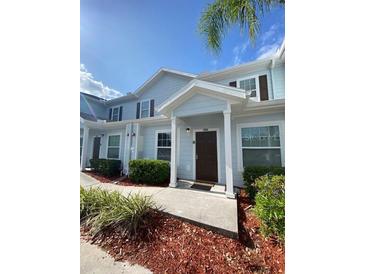 Inviting townhome featuring blue siding, shuttered windows, and a covered entryway at 5370 Diplomat Ct # 107, Kissimmee, FL 34746