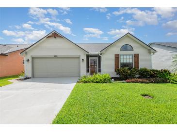 Charming single-story home featuring a two-car garage and lush, well-manicured front lawn at 685 Middlebury Loop, New Smyrna Beach, FL 32168