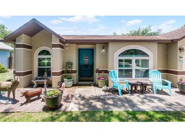 Charming home featuring a cozy front porch with blue chairs and decorative accents at 891 Licaria Dr, Ocoee, FL 34761