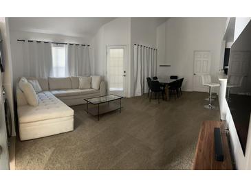 Bright living room featuring neutral decor, a modern sofa, and a glass coffee table at 970 N Spring Garden Ave # 621, Deland, FL 32720
