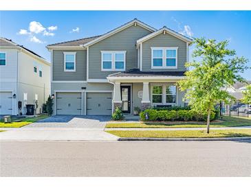 Charming two-story home features a two-car garage, landscaped yard, and inviting front porch at 11479 Satire St, Orlando, FL 32832
