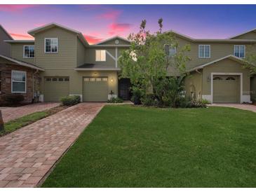 Beautiful two-story home with a well-manicured lawn and brick driveway at 2311 Chatham Place Dr, Orlando, FL 32824