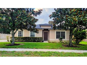 Charming single-story home with a well-manicured lawn and beautiful landscaping at 2555 Palmetto Ridge Cir, Apopka, FL 32712
