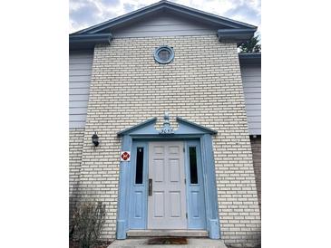 Charming brick home with a blue trimmed entrance and a centered, round window above the door at 3057 Aaron Burr Ave # 2, Winter Park, FL 32792