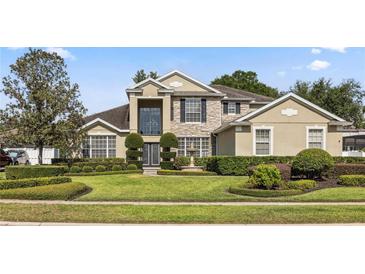 Inviting two-story home with stone accents, manicured lawn, fountain, and lush landscaping at 325 Green Ash Ln, Sanford, FL 32771