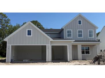 Charming two-story home with a two-car garage, showcasing a modern farmhouse design at 340 Ambersweet Pl, Lake Mary, FL 32746