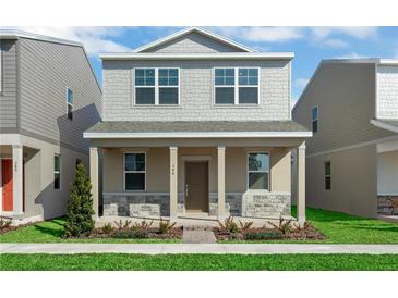 Charming two-story home featuring a stone-accented facade, covered porch, and beautifully landscaped front yard at 490 Belmond Dr, Debary, FL 32713