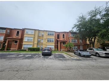 Multi-Gathering home with a parking lot and some lawn area with mature trees, creating a pleasant atmosphere at 5160 Conroy Rd # 1437, Orlando, FL 32811