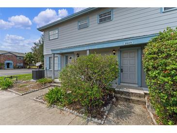 Two-story home featuring a grey painted facade, landscaping, and a covered entryway at 7449 Daniel Webster Dr # 3, Winter Park, FL 32792