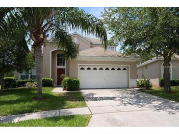 Charming two-story home featuring a two-car garage, well-maintained landscaping, and a welcoming entrance at 8113 Sun Palm Dr, Kissimmee, FL 34747