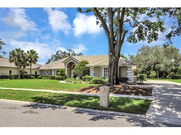 Stunning single-story home with manicured lawn and mature landscaping creating a welcoming curb appeal at 8623 Summerville Pl, Orlando, FL 32819