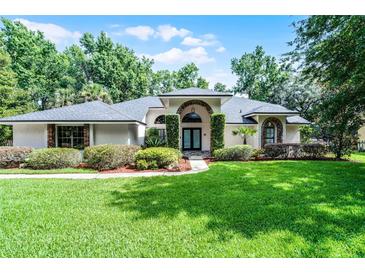 Charming home with lush green lawn, manicured bushes, and an inviting front entrance at 2608 Westminster Ter, Oviedo, FL 32765