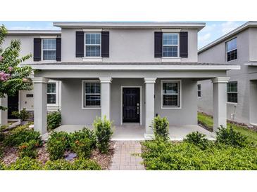 Charming front exterior featuring gray siding, dark shutters, and a welcoming covered porch at 3124 Addison Blvd, St Cloud, FL 34771