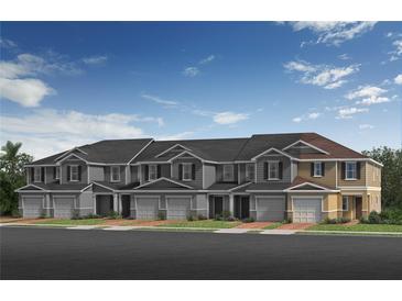 Charming townhomes featuring attached garages and manicured front lawns under a bright blue sky at 504 Pine Ridge Ct, Lake Wales, FL 33859