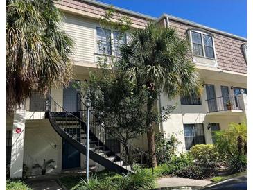 Charming multi-Gathering unit featuring a black staircase, well-maintained landscaping, and tropical palm trees at 5930 Village Cir # Ge, Orlando, FL 32822