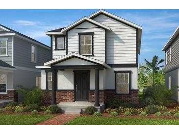 Charming two-story home with white siding, brick accents, and a well-manicured lawn with shrubs at 7212 Big Cedar Aly, Groveland, FL 34736