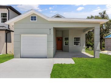Charming home with a one-car garage, modern exterior, and a neatly maintained front yard at 817 E Mcdonald Ave, Eustis, FL 32726