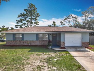 Charming single-story home with brick accents, lush lawn, and an attached one car garage in a tranquil setting at 1276 Comerwood Dr, Deltona, FL 32738