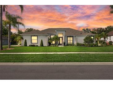 Charming single Gathering home exhibiting a well-manicured lawn, complemented by palm trees and lush landscaping at 1301 Johns Cove Ln, Oakland, FL 34787