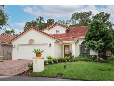 Charming single-Gathering home showcasing a well-manicured lawn, tile roof, and two-car garage at 1364 Augusta National Blvd, Winter Springs, FL 32708