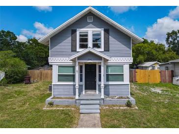 Charming two-story home featuring a symmetrical facade, gray siding, and a well-manicured lawn at 1504 Indiana Ave, St Cloud, FL 34769