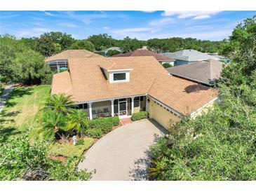 Charming home with a tan exterior, brick paver driveway, and lush landscaping at 217 Lake Cassidy Dr, Kissimmee, FL 34759