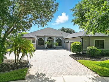 Well maintained home with a paver driveway, arched windows, and nicely manicured landscaping at 2308 Bur Oak Ct, Oviedo, FL 32766